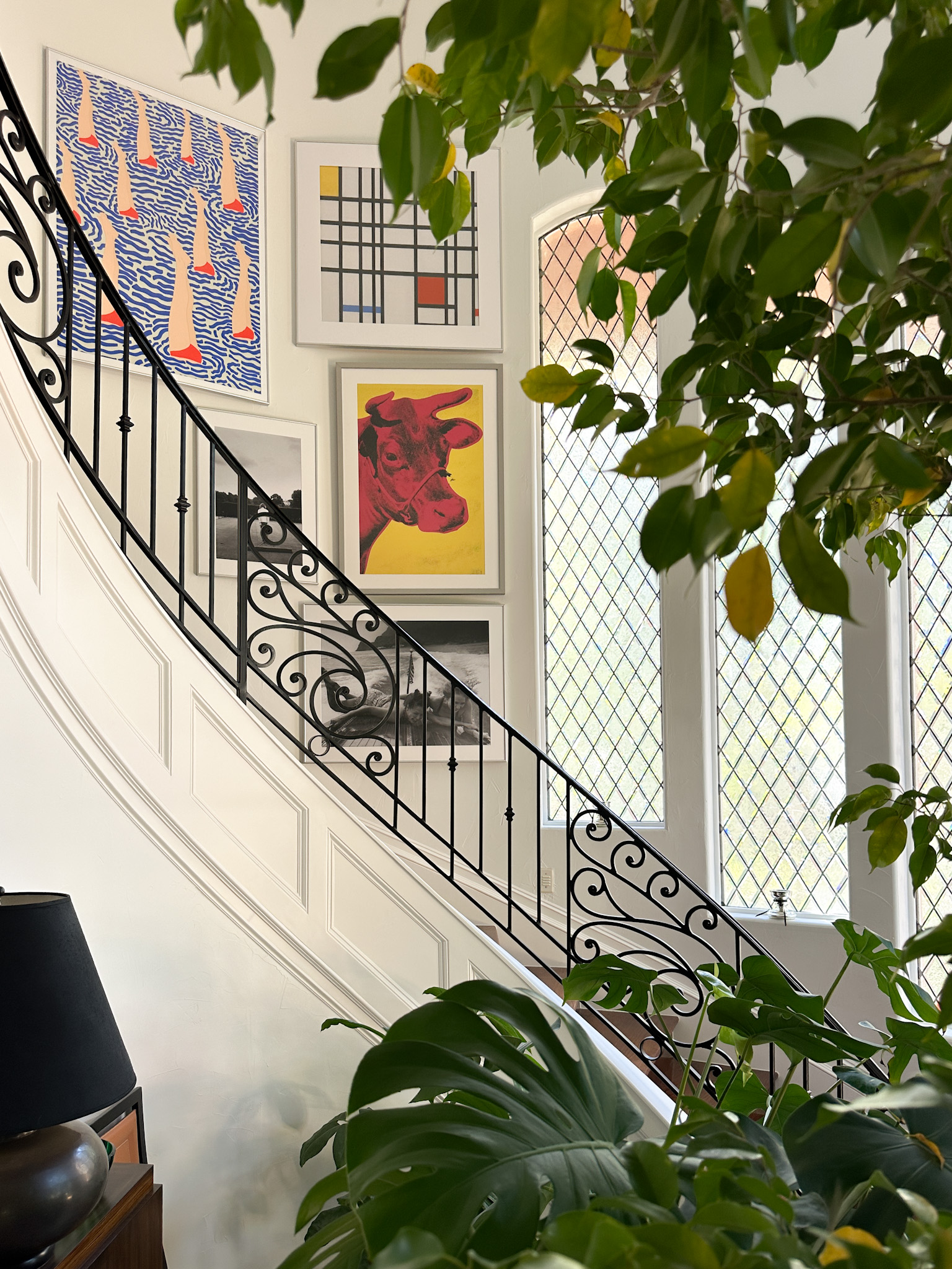 curved stairway gallery wall with bright art